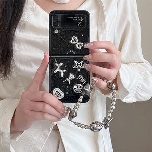 Dettaglio custodia glitterata nera per Samsung Z Flip con ciondoli 3D e cinturino da polso
