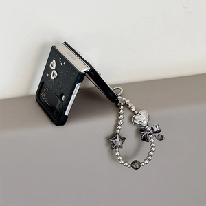 Dettaglio della custodia glitter Samsung Z Flip con cuori metallici e catena di perle
