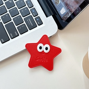 Détail du support téléphone étoile en cuir rouge avec yeux et logo Smile sur laptop