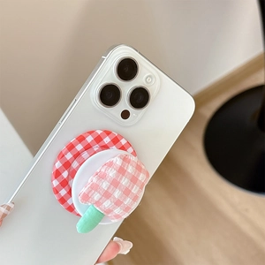 Detail of creative plaid popsicle fabric phone grip mount on a white smartphone