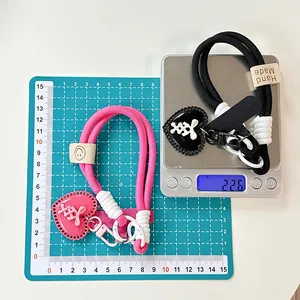 Close-up of handmade woven heart charms showing weight measurement and size details