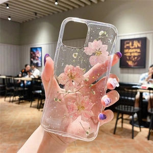 Détail de la coque en résine transparente avec de vraies fleurs séchées roses et paillettes