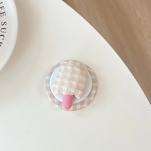 Detail of popsicle-shaped checkered plush phone socket on matching circular magnetic base