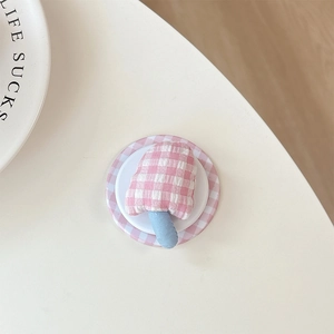 Close-up of pink checkered mushroom phone grip with soft fabric texture and round base