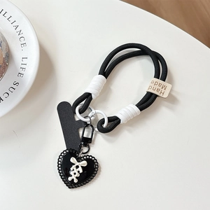 Detail of handmade heart charm phone strap with thick black cord and stitch accents