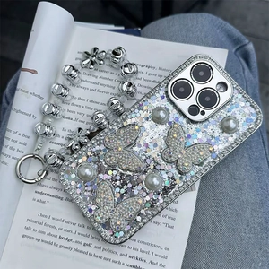 Detail of glitter butterfly iPhone case with pearl accents and floral metal wrist strap