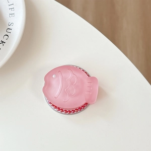Detailed view of pink fish-shaped phone socket with glitter texture and pearl accents