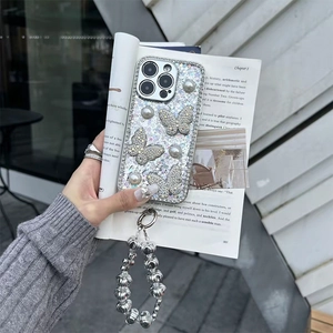 Close-up of glitter iPhone case with diamond butterfly, pearls, and silver ball lanyard