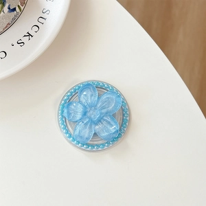 Close-up of blue floral magnetic phone grip with glitter petals and pearl edge detail