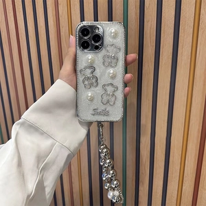 Close-up of pearl bear iPhone case with glitter finish, rhinestone edges and smile charm