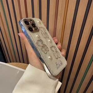 Detail of iPhone case with silver electroplated edge, pearls, and glittery bear motifs
