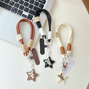 Close-up of star-shaped braided phone charms in brown, black, and white colors