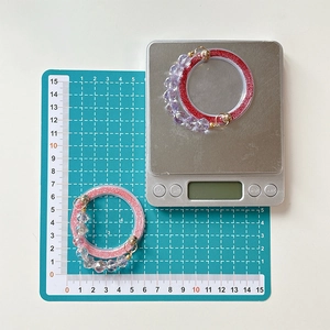 Detail of magnetic glitter phone base with purple and white faceted beads on a scale