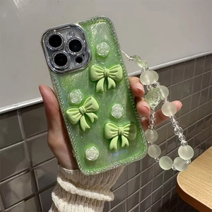 Detail of light green glitter iPhone case with 3D bows, flowers and beaded wrist strap