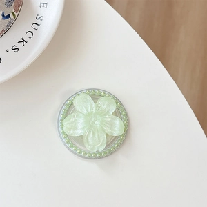 Macro shot of light green flower phone grip with pearl accents and shimmering finish