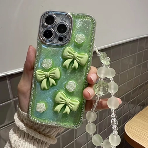 Detail of glitter iPhone case with 3D green bows, white roses and crystal rhinestone trim