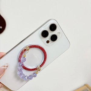 Magnetic phone grip with red glitter ring and lavender acrylic beaded hand strap on a white phone