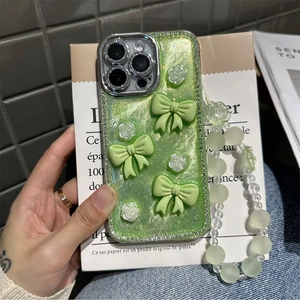Light green glitter iPhone case with 3D bows, floral charms and a beaded hand strap
