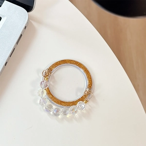 Detail of glitter bead magnetic phone stand with sparkling golden base on a desk