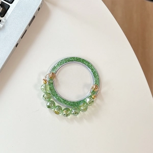 Sparkly green glitter phone socket with faceted crystal bead strap on white desk