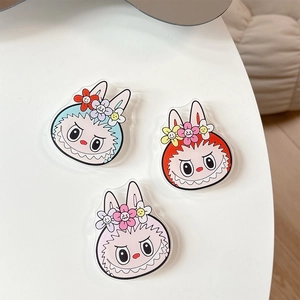 Detailed view of three colorful Labubu-style rabbit acrylic charms on a white surface