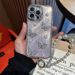Close-up of glitter iPhone case with silver butterfly motifs and pearl wrist strap