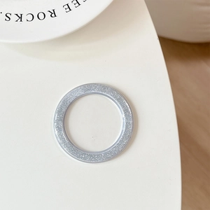 Detail of silver glitter phone grip base with a shiny textured finish on a white surface