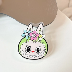 Close-up of green acrylic cartoon monster rabbit phone grip with three colorful flowers
