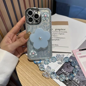Detail of blue glitter phone case with pearl flower and beaded wrist strap for iPhone