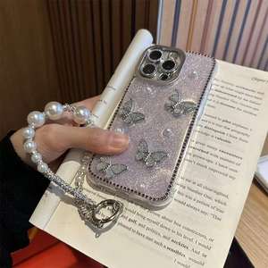 Detail of purple glitter iPhone case with silver butterflies and pearl strap accessory