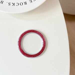 Macro view of red glitter circular magnetic phone grip base on a white surface