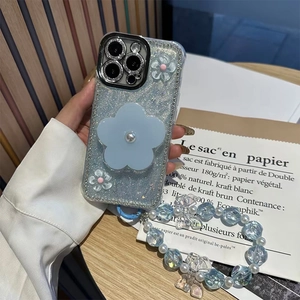 Detail of glitter iPhone case with blue flower grip and elegant pearl wrist strap