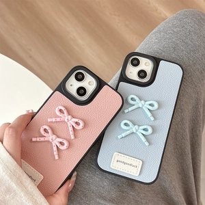 Litchi pattern leather iPhone case with 3D bows and goodgoodluck label in pink and blue