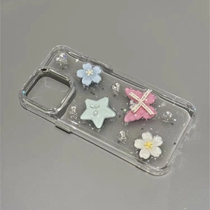 Glittery transparent iPhone case with 3D butterfly, stars, and floral resin decorations