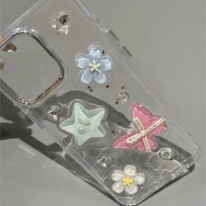 Clear iPhone 16 Pro Max case with 3D blue flowers, pink butterfly, and mint green star deco