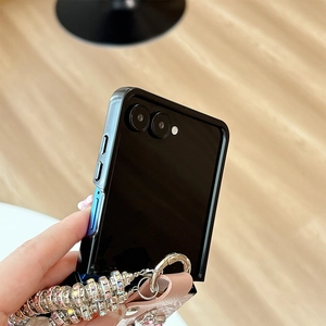 Detail of black folding case with sparkling rhinestone strap and pink leather charm