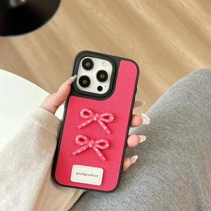 Detail of magenta lychee leather iPhone case with 3D pink polka dot bows and luck tag
