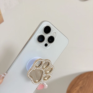 Sparkling gold cat paw phone socket stand with rhinestones on a white smartphone