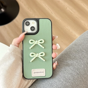 Detail of green lychee leather iPhone case with 3D bows and 'goodgoodluck' label
