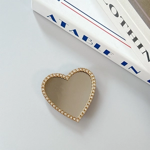 Close-up of heart-shaped phone grip with mirror center and crystal rhinestone border