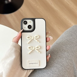 Detail of white lychee leather iPhone case with cream bows and goodgoodluck label