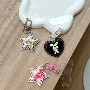 Porte-clés mignons en forme d'étoile et de cœur avec nœuds sur un plateau blanc