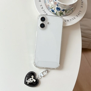 Gros plan sur la coque de téléphone avec pendentif cœur noir et détail de ruban blanc