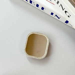 Detail of square vanity mirror phone grip with sparkling rhinestone frame and brown lens