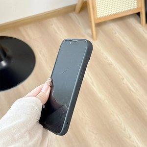 Macro detail of black leather phone case featuring side lanyard hole for iPhone 16 Pro Max