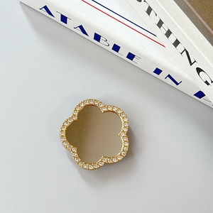 Detailed view of flower-shaped phone grip with sparkling rhinestones and a mirror surface
