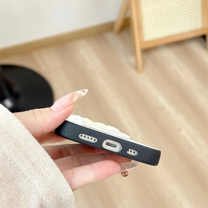 Close-up of precise charging port and speaker cutouts on black leather phone case