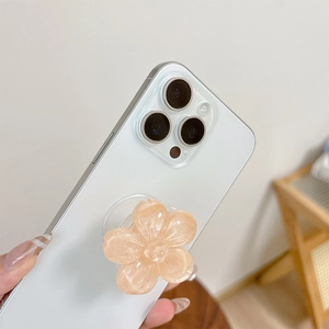 Dettaglio macro del supporto per telefono a forma di fiore glitterato su smartphone bianco