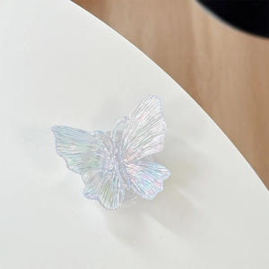 Macro detail of 3D iridescent butterfly phone grip with radial texture on white background