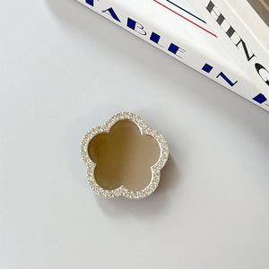 Detail of flower phone grip with sparkling rhinestones and a gold mirror surface